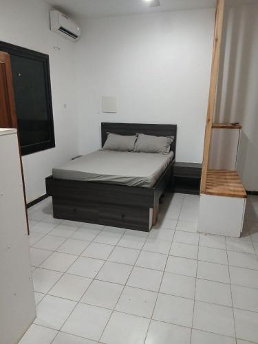 a bedroom with a bed in the corner of a room at L'hospitalité in Thies