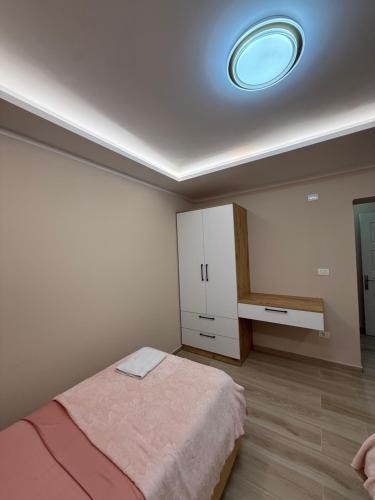 a bedroom with a bed and a sink and a ceiling at Alea Home in Fier