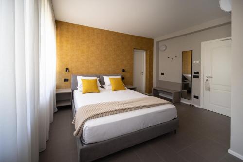 a bedroom with a large bed with yellow pillows at Small Guesthouse in Bussolengo