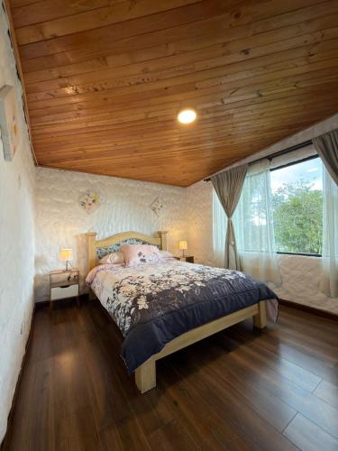 a bedroom with a bed and a wooden ceiling at Vereda San Jorge Chalet in Zipaquirá