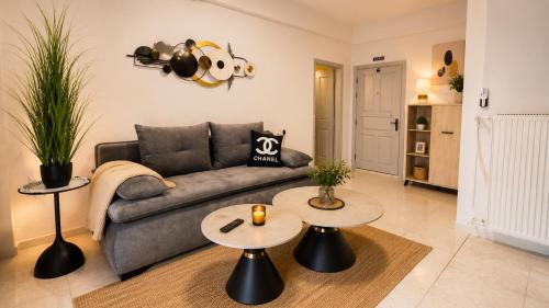 a living room with a couch and two tables at Paralia Sea View Suites in Paralia Katerinis