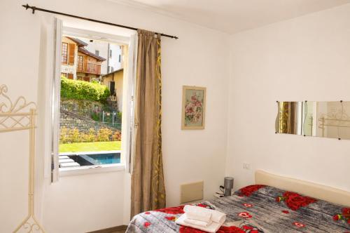 a bedroom with a bed and a window at Lescen White Residence - Lake View in Lezzeno