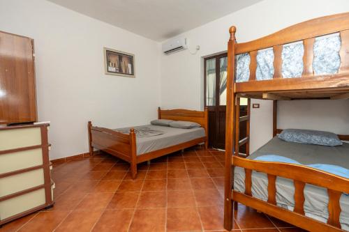 a bedroom with two bunk beds and a kitchen at Vila Pushimi Klaudio in Velipojë