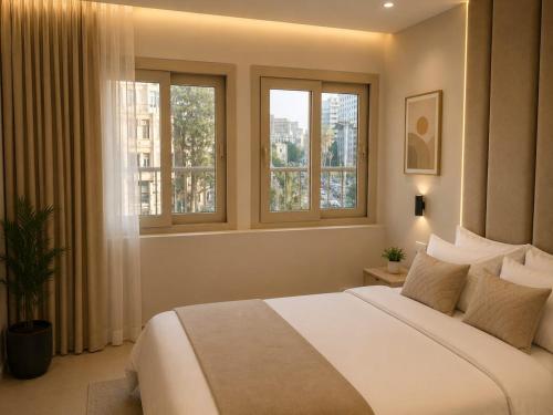 a bedroom with a large bed and two windows at Royal Town Hotel in Cairo