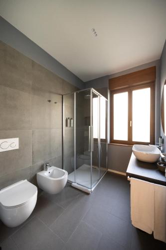 a bathroom with two sinks and a toilet and a shower at Small Guesthouse in Bussolengo