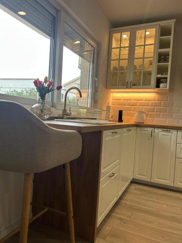 a kitchen with white cabinets and a sink at Apartman LaVida in Kaštela