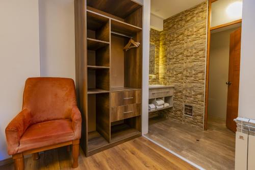 an orange chair in a room with a closet at Estancia San Pedro Hotel in Cusco
