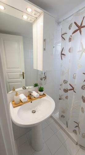 a white bathroom with a sink and a shower at Kalamata Deluxe Suite By AGGELOS in Kalamata