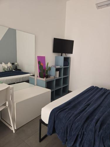 a bedroom with a bed and a desk and a tv at fico d'india in Spadafora