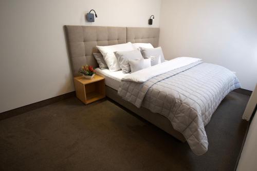 a bedroom with a large bed with white sheets and pillows at Hotel Stork in Lednice
