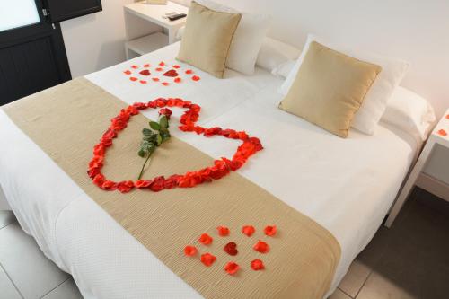 a bed with a heart made out of red roses at La Pasajera Hostal Boutique in Conil de la Frontera