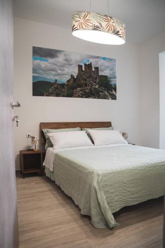 a bedroom with a bed with a castle painting on the wall at 3Season Ortona B&B in Ortona