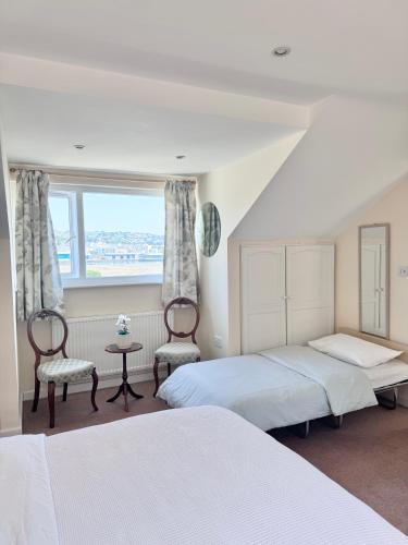 a bedroom with two beds and a window at Broadlands View in Shaldon