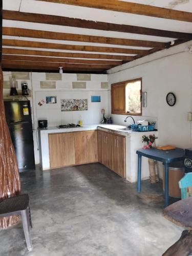 a kitchen with wooden cabinets and a blue table at Cabaña Murringo a dos minutos en coche de Necobotes en Necoclí in Necoclí