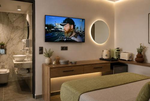 a bedroom with a tv on a wall with a bed at Casa Enetiko in Chania