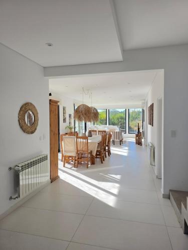 a dining room and living room with a table and chairs at COSTA ESMERALDA S3 para 10 pileta y jardín privados in Pinamar