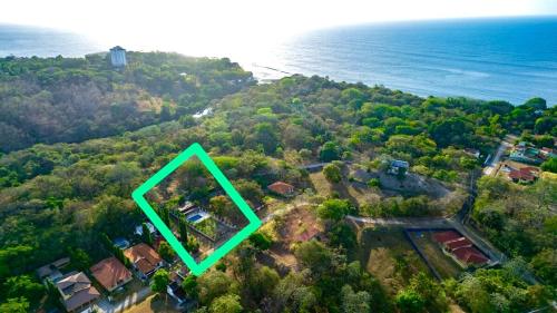 an aerial view of a house on a hill next to the ocean at Majestic Sands in San Carlos