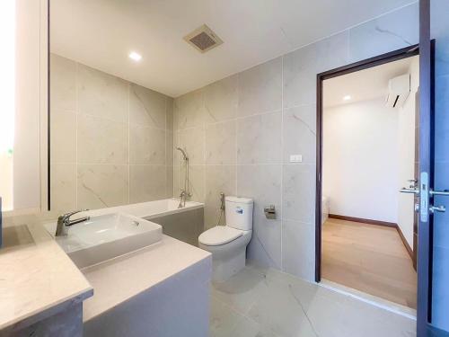 a bathroom with a toilet and a tub and a sink at The Astra Residence in Chiang Mai