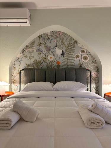 a bedroom with a large white bed with a floral wallpaper at Nia The Nest in Nafpaktos