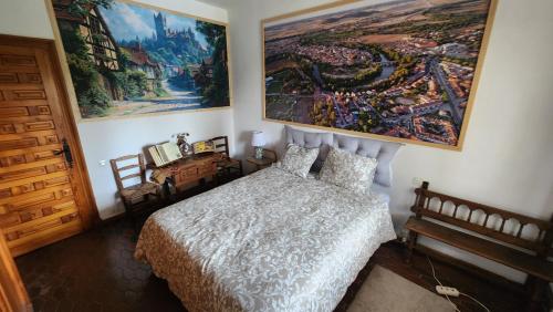 a bedroom with a bed and a large painting on the wall at Campoarique in Tudela de Duero