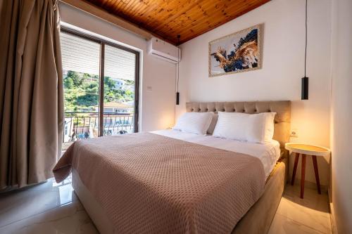 a bedroom with a bed and a large window at B&B Sunny Side in Sarandë