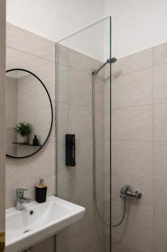 a bathroom with a shower and a sink and a mirror at B&B Sunny Side in Sarandë