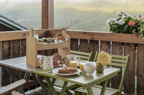 a table with breakfast food on a balcony at Sloho Bergurlaub - Adults Only in Hohentauern