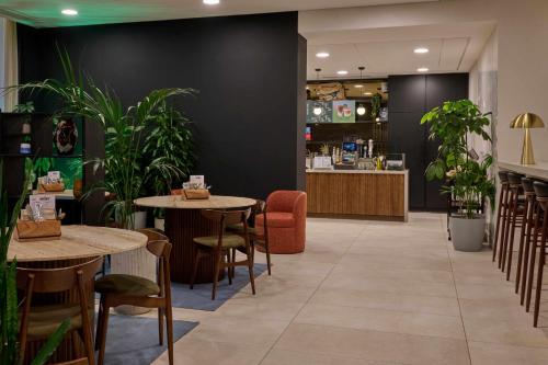 a restaurant with tables and chairs and plants at Cove Landmark Pinnacle in London