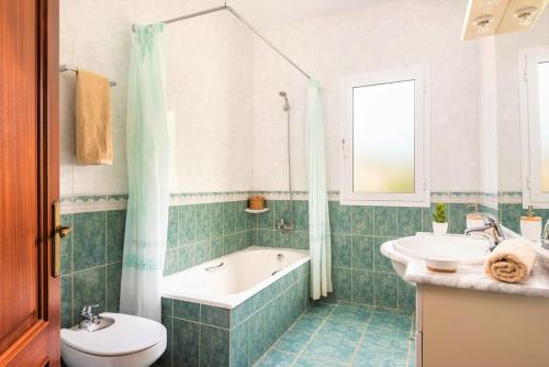 a bathroom with a tub and a toilet and a sink at Villa Son Domingo by Villa Select in Alaior