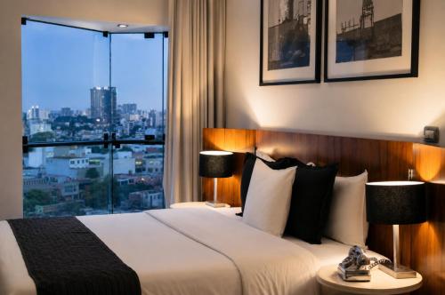 a hotel room with a bed and a large window at BTH Hotel – Boutique Concept in Lima