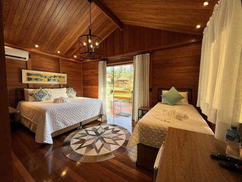 a bedroom with two beds and a window at Chalé dos Lagos Ecoresort in Mandaguaçu