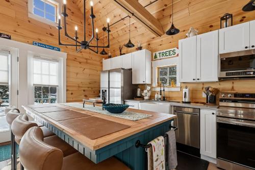 a kitchen with white cabinets and a wooden ceiling at Maple Chalet in Morrisville