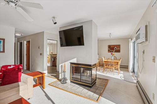 a living room with a fireplace and a tv at Mountainside Condo J202 in Stowe