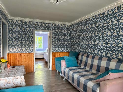 a living room with a couch and wallpaper at Elasia in Martvili