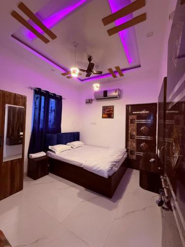 a bedroom with a bed with purple lights on the ceiling at Roshan's INN Hotel in Patna