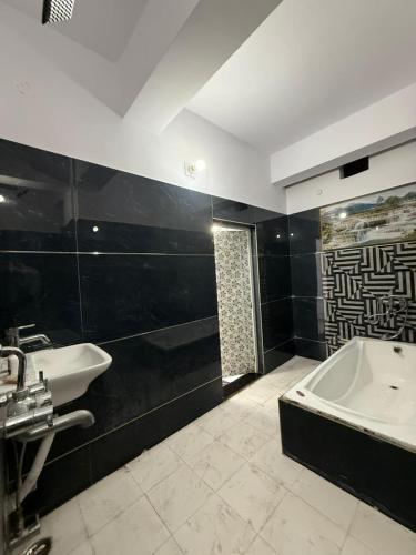 a bathroom with a bath tub and a sink at Roshan's INN Hotel in Patna