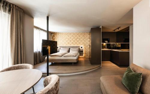 a bedroom with a bed and a table and chairs at Avita suites Ortisei in Ortisei