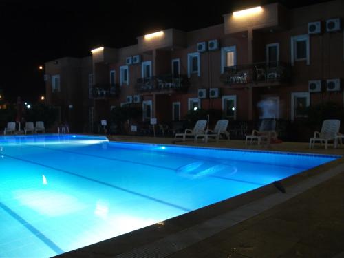 a large swimming pool in front of a building at night at Samdan Hotel in Pamukkale