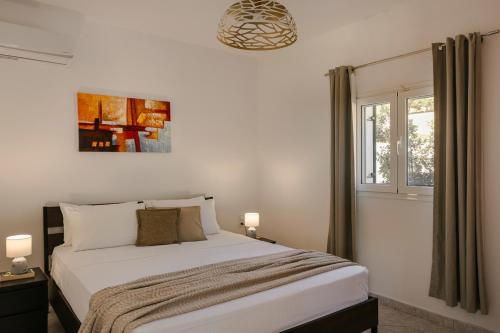 a bedroom with a large bed and a window at Villa George by Villa Select in Lourdata