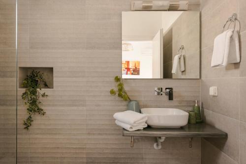 a bathroom with a sink and a mirror at Villa George by Villa Select in Lourdata