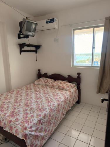 a bedroom with a bed and a tv on the wall at Flat em Sao Jose da Coroa Grande in São José da Coroa Grande