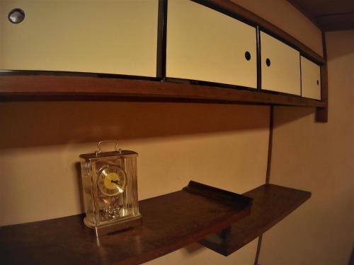 a clock sitting on a shelf in a room at Guest House Ga-Jyun in Kyoto