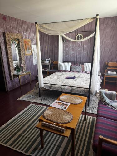 a bedroom with a canopy bed and a table at Romantic Studio Suite with Sauna in Pyussi