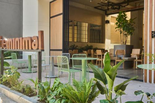 a cafe with green tables and chairs and plants at beminimal jardines in Medellín