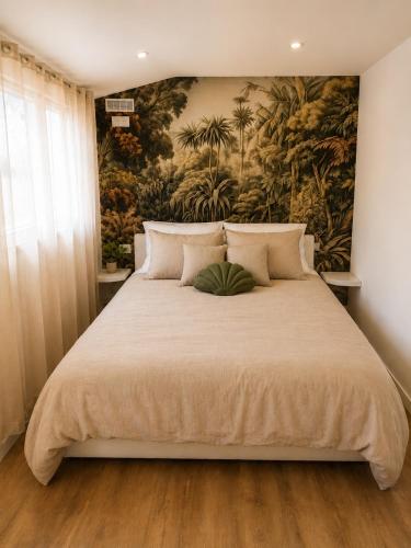 a bedroom with a large bed with a painting on the wall at La Cachette - Studio Nature - Terrasse Privée in Corbeil-Essonnes