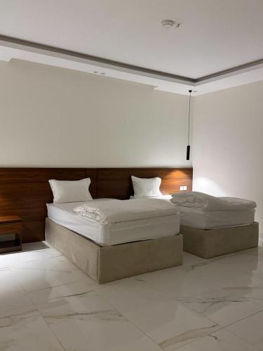 two twin beds in a room with white walls at STAYs ستايز in Medina