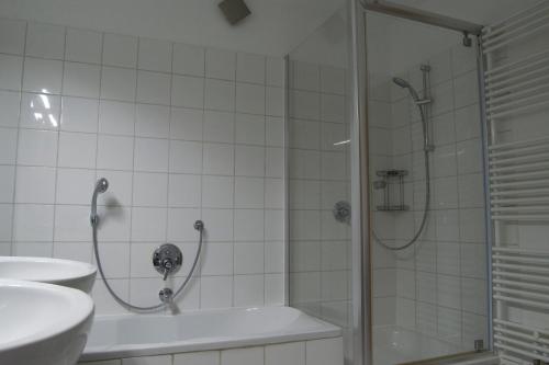 a bathroom with a shower and a tub and a sink at Sleep & Go - Sechsbettzimmer inkl 2 Luftbetten mit Gemeinschaftsbad in Sonthofen