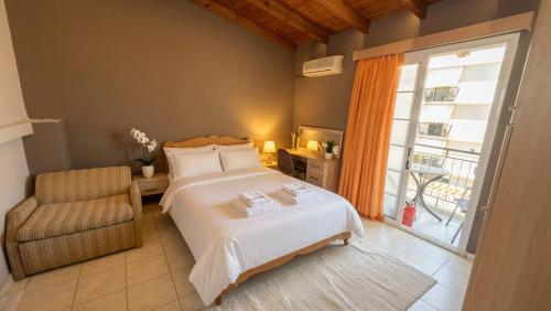 a bedroom with a bed and a chair and a window at Kalamata Penthouse By PAVLOS in Kalamata