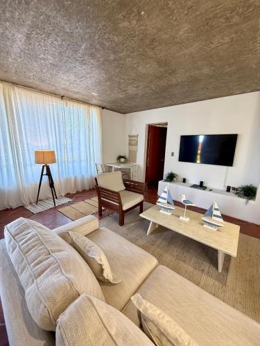 a living room with a couch and a tv at Hotel Green en Marbella in Maitencillo