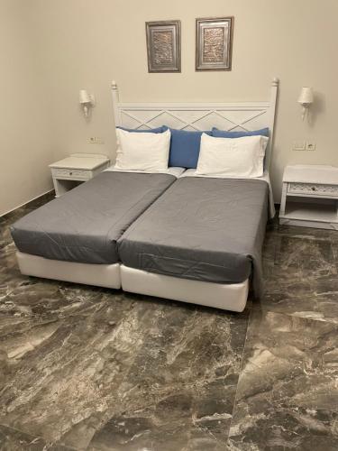 a bedroom with a large bed with two night stands at Dionisia apartments in Kos